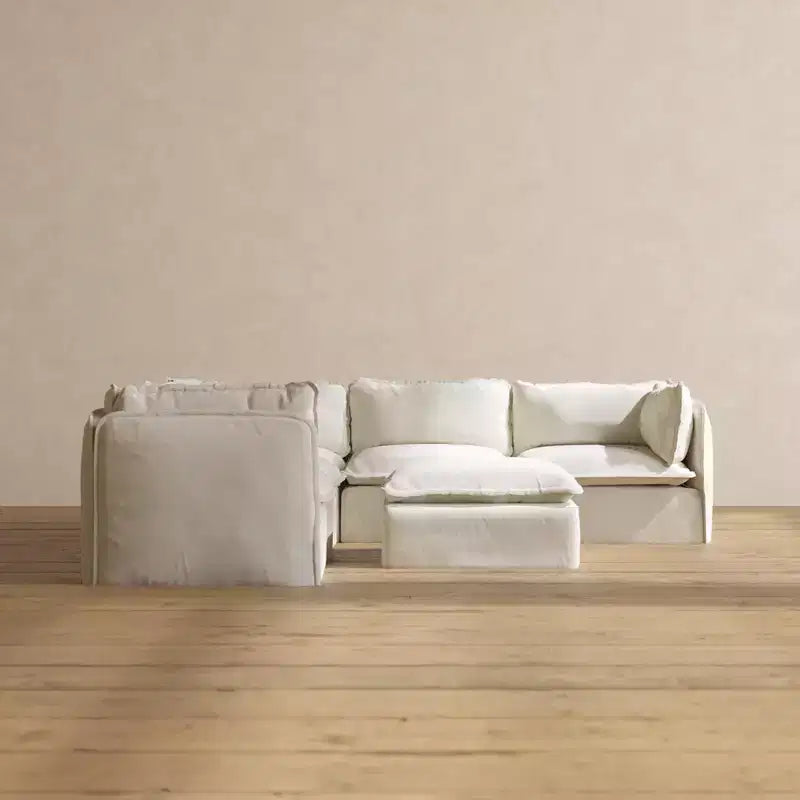 Divano componibile angolare Anabei lavabile a 5 posti + pouf | seduta Deluxe+ e cuscino cloud